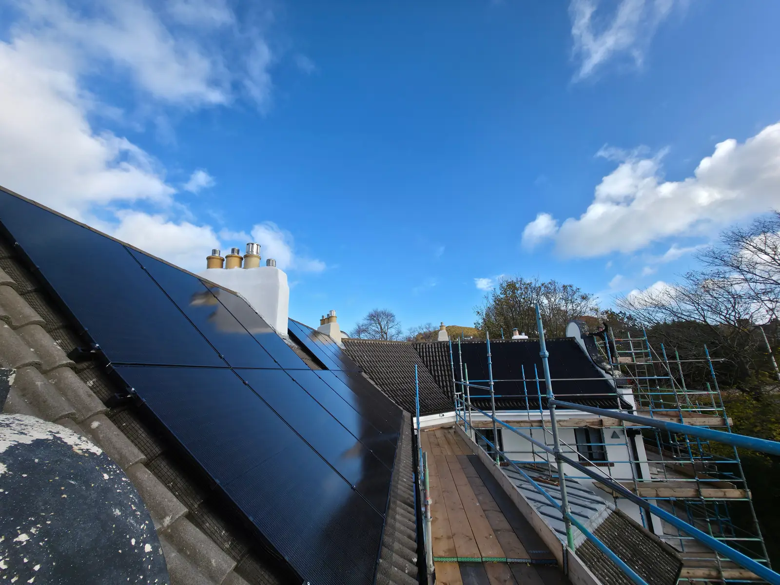 Solar PV panels running up to the ridge on a Scottish rooftop